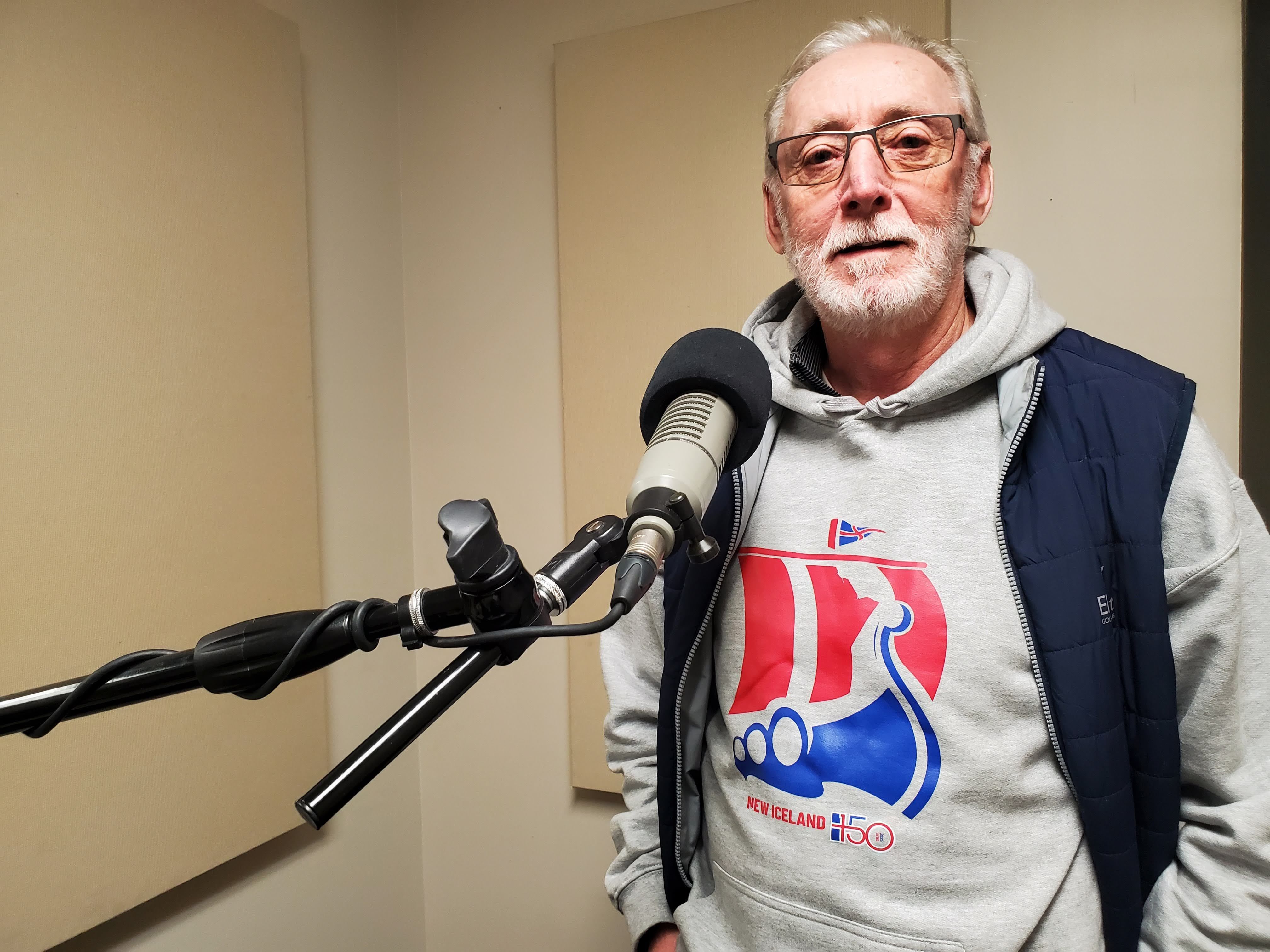 A man poses for a photo in a radio studio
