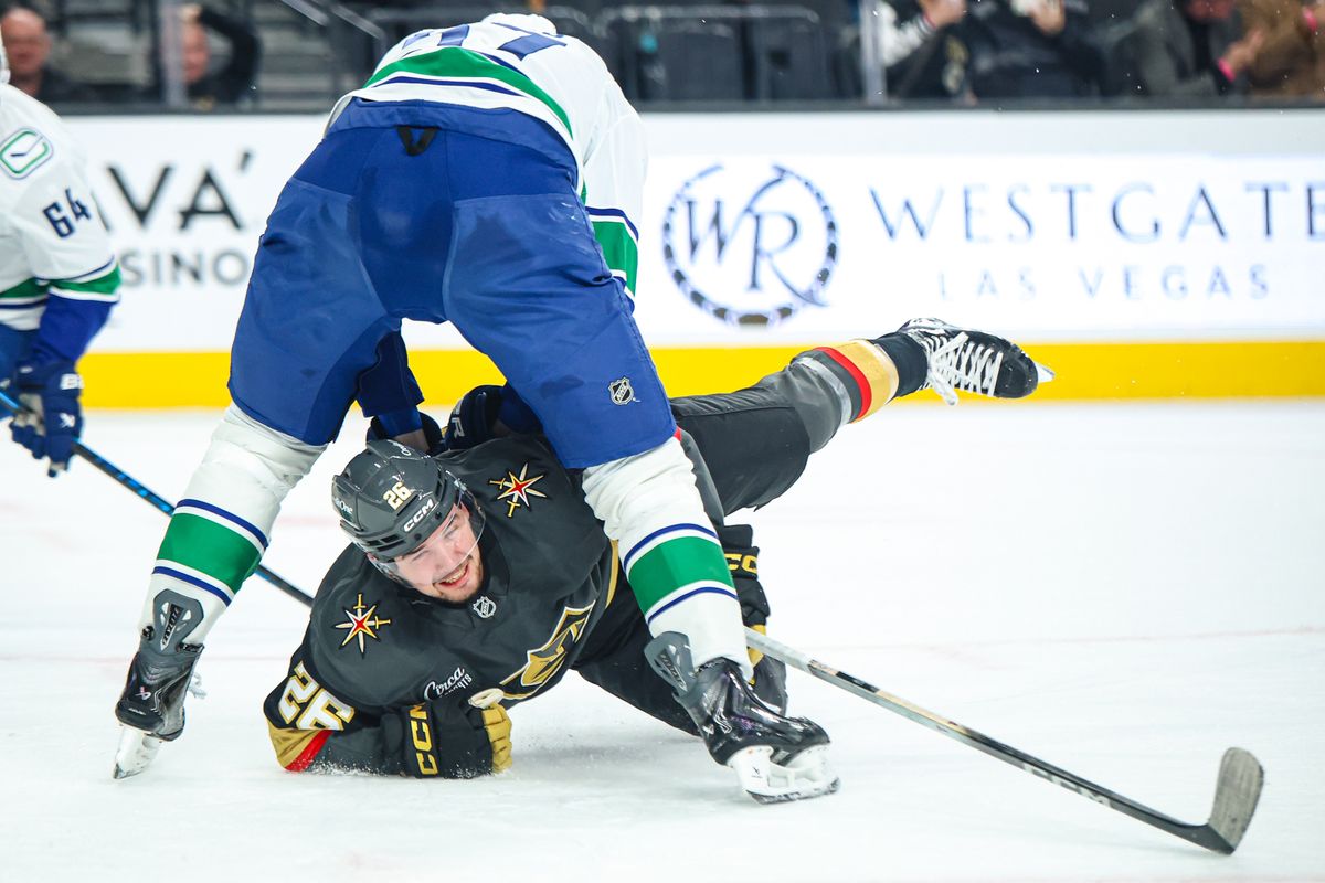 Vegas Golden Knights F Alexander Holtz (26) reaches for the puck between the legs of Vancouver Canucks D Tyler Myers (57) on Wednesday February 4, 2026, in Las Vegas, Nevada. 