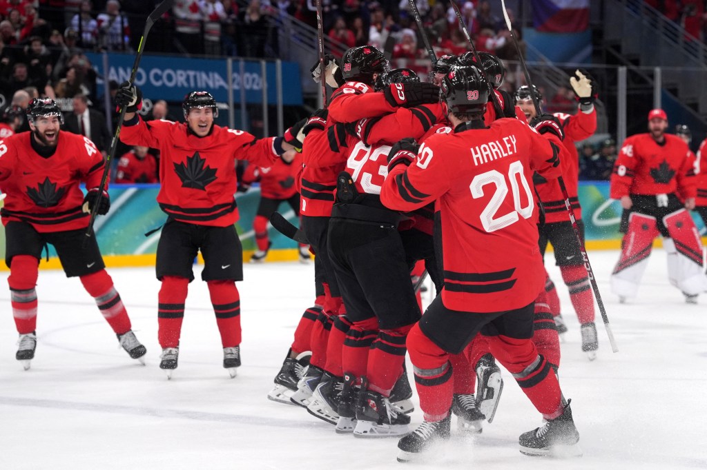 Milan, Italy; Mitch Marner of Canada celebrates with teammates after scoring their fourth goal in overtime to win the match against Czechia in a men's ice hockey quarterfinal during the Milano Cortina 2026 Olympic Winter Games at Milano Santagiulia Ice Hockey Arena.