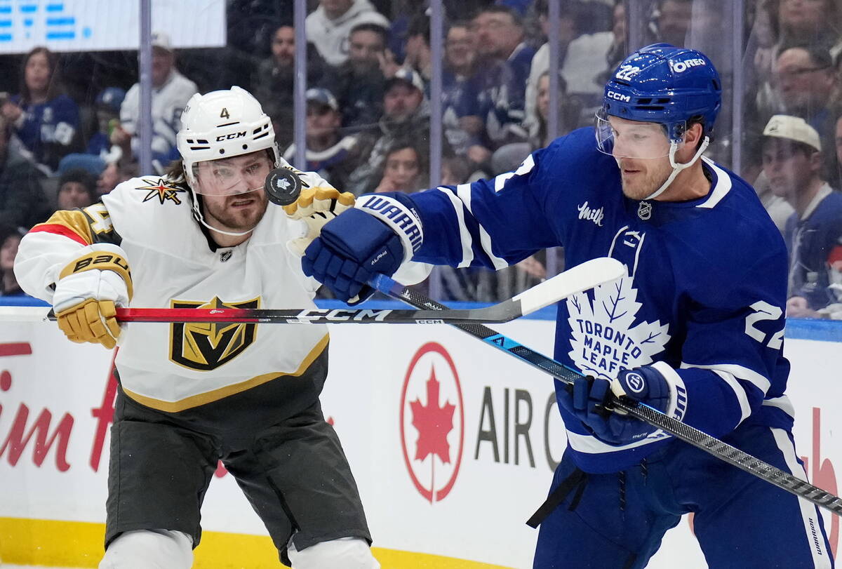 Vegas Golden Knights Rasmus Andersson (4) battles for the puck with Toronto Maple Leafs' J ...