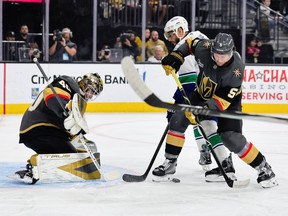 Akira Schmid #40 and Jeremy Lauzon #5 of the Vegas Golden Knights defend the net against Evander Kane in the first period