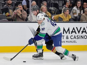 Liam Ohgren of the Vancouver Canucks and Pavel Dorofeyev of the Vegas Golden Knights vie for the puck in the first period