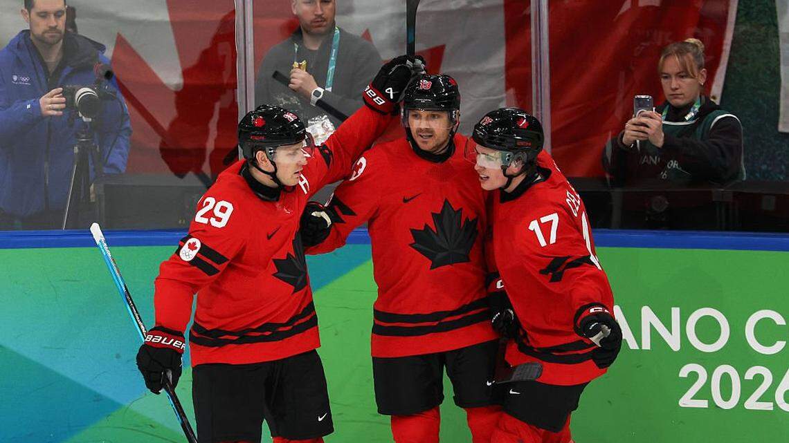 MILAN, ITALY - FEBRUARY 20: Sam Reinhart #13 of Team Canada celebrates with teammates Nathan MacKinnon #29 and Macklin Celebrini #17 of Team Canada after scoring a goal in the second period during the Men's Semifinals Playoff match between Canada and Finland on day fourteen of the Milano Cortina 2026 Winter Olympic games at Milano Santagiulia Ice Hockey Arena on February 20, 2026 in Milan, Italy. (Photo by Jamie Squire/Getty Images)