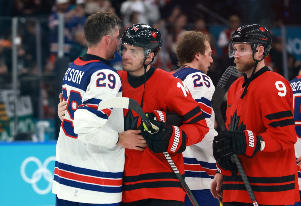 Brock Nelson #29 of Team United States hugs Bo Horvat #14 of Team Canada after the Men's Gold Medal match between Canada and the United States on day 16 of the Milano Cortina 2026 Winter Olympic games at Milano Santagiulia Ice Hockey Arena on February 22, 2026 in Milan, Italy. The United States defeated Canada 2-1 in overtime. 