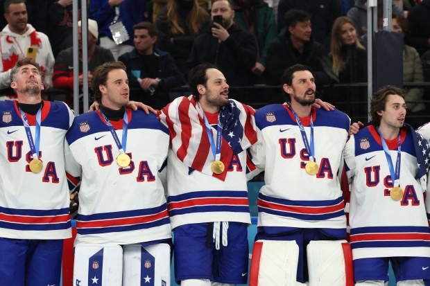 Gold medalists Brock Nelson #29, Jake Oettinger #30, Auston Matthews #34, Connor Hellebuyck #37 and Quinn Hughes #43 of Team United States listen to the national anthem during the medal ceremony for Men's Ice Hockey following their gold-medal win during the Men's Gold Medal match between Canada and the United States on day 16 of the Milano Cortina 2026 Winter Olympic games at Milano Santagiulia Ice Hockey Arena on Feb. 22, 2026, in Milan, Italy. (Photo by Bruce Bennett/Getty Images)