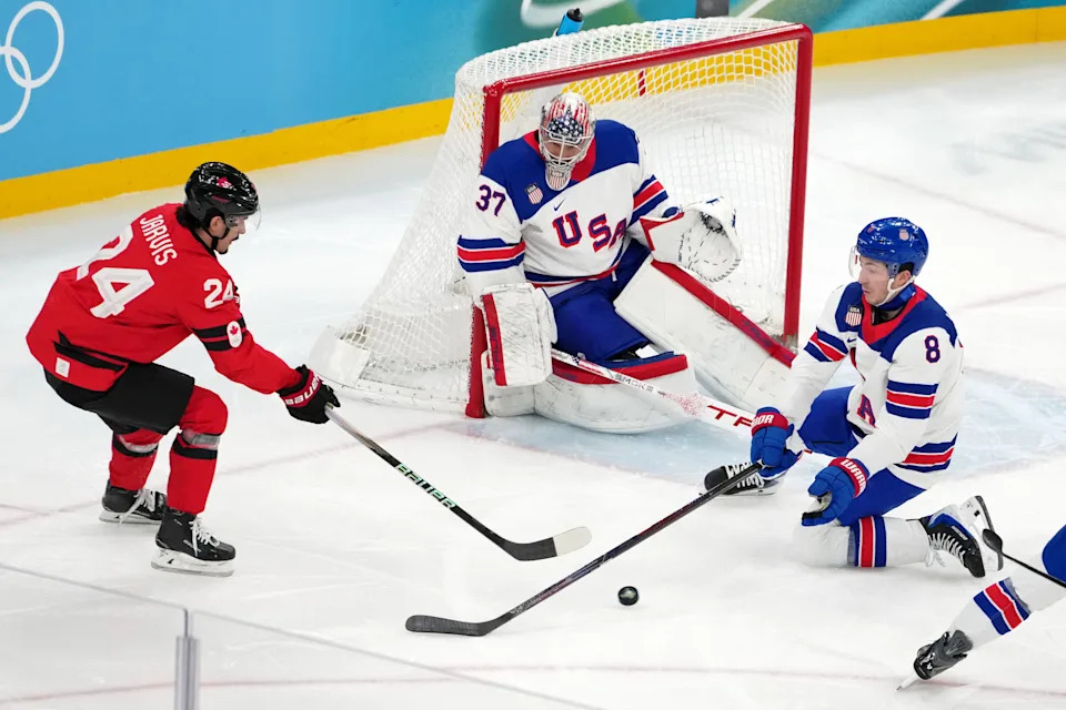 Feb 22, 2026; Milan, Italy; Seth Jarvis of Canada battles for the puck against Zach Werenski of the United States during the men's ice hockey gold medal game during the Milano Cortina 2026 Olympic Winter Games at Milano Santagiulia Ice Hockey Arena. Mandatory Credit: James Lang-Imagn Images