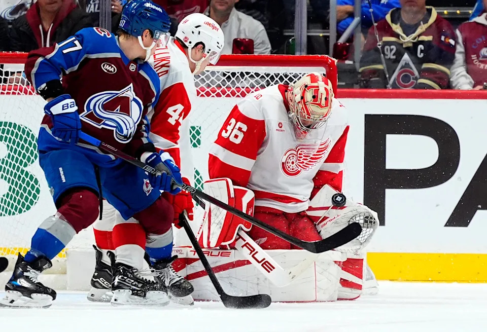 Detroit Red Wings goaltender John Gibson (36) makes a save next to defenseman Axel Sandin-Pellikka (44) and Colorado Avalanche center Parker Kelly (17) in the first period at Ball Arena in Denver on Monday, Feb. 2, 2026.