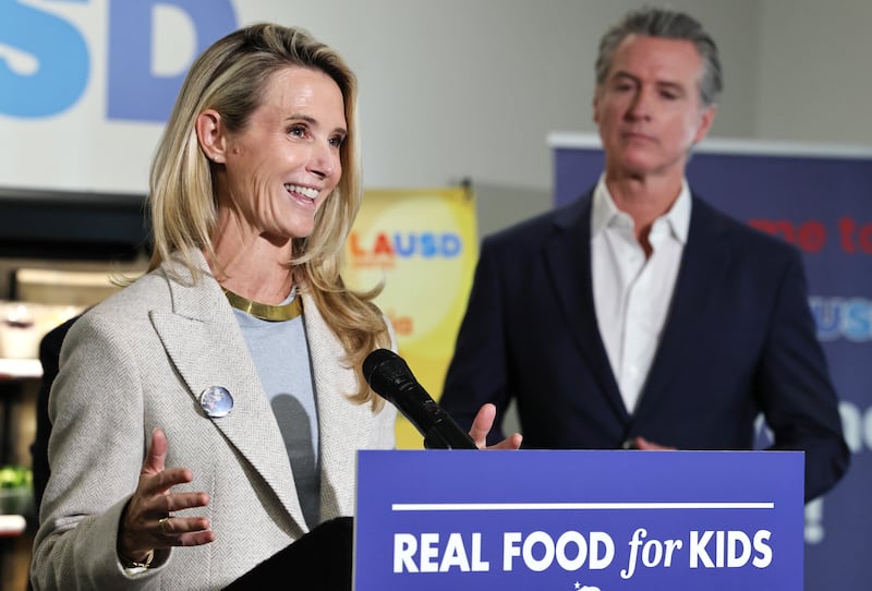 LOS ANGELES, CALIFORNIA - OCTOBER 08: California Governor Gavin Newsom looks on as his wife Jennifer Siebel Newsom speaks at Belvedere Middle School before he signed legislation aimed at improving kids' nutrition and health across California on October 8, 2025 in Los Angeles, California. The bill bans ultra-processed foods (UPFs) from school meals in the state. (Photo by