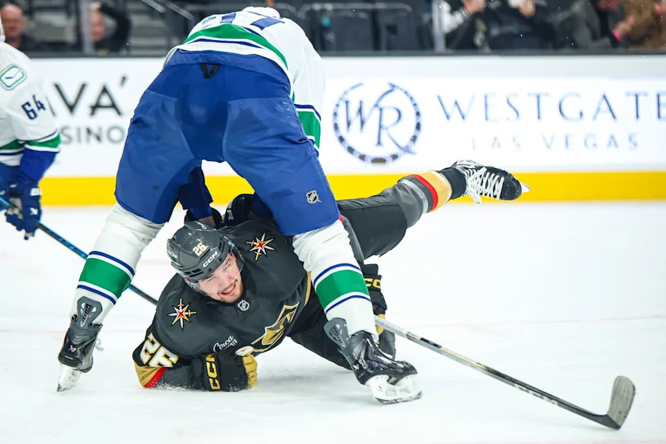 Vegas Golden Knights F Alexander Holtz (26) reaches for the puck between the legs of Vancouver Canucks D Tyler Myers (57) on Wednesday February 4, 2026, in Las Vegas, Nevada. 