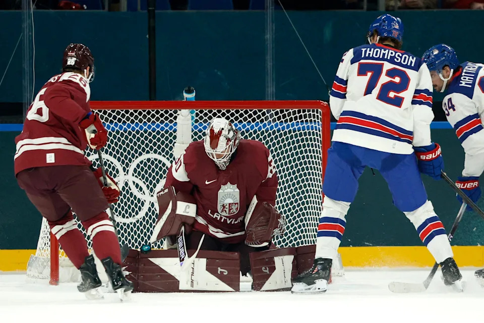 Feb 12, 2026; Milan, Italy; Tage Thompson of United States in action with Elvis Merzlikins of Latvia and Uvis Janis Balinskis of Latvia in men's ice hockey group C play during the Milano Cortina 2026 Olympic Winter Games at Milano Santagiulia Ice Hockey Arena. Mandatory Credit: Geoff Burke-Imagn Images