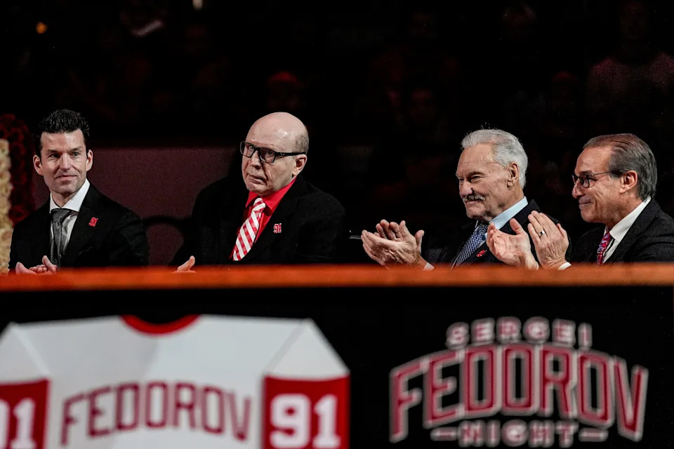 Vladimir Konstantinov, center left, applauds, next to Ryan Gustafson, President and CEO of Ilitch Sports + Entertainment, left, and Mickey Redmond, and Ken Daniels during Sergei Fedorov’s jersey retirement ceremony at Little Caesars Arena in Detroit on Monday, Jan. 12, 2026.