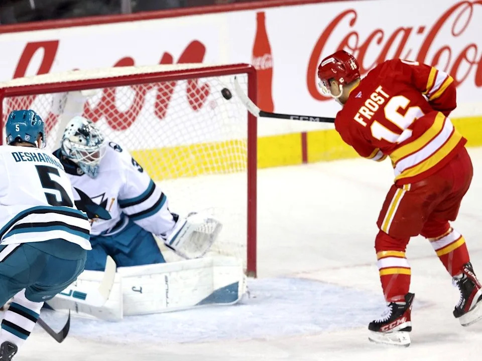  Flames forward Morgan Frost scores on Sharks goalie Alex Nedeljkovic during Saturday’s game.