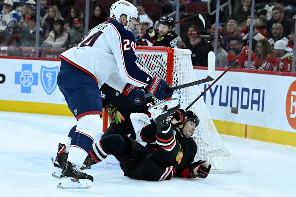 Jan 30, 2026; Chicago, Illinois, USA; Columbus Blue Jackets right wing Mathieu Olivier (24) knocks down Chicago Blackhawks center Ryan Donato (8) during the first period at the United Center. Mandatory Credit: Matt Marton-Imagn Images