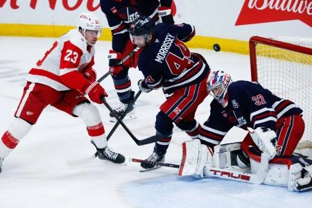 Jan 24, 2026; Winnipeg, Manitoba, CAN; Detroit Red Wings forward Lucas Raymond (23) scores on Winnipeg Jets goalie Connor Hellebuyck (37) during the third period at Canada Life Centre. Mandatory Credit: Terrence Lee-Imagn Images