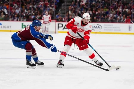 Feb 2, 2026; Denver, Colorado, USA; Detroit Red Wings center Marco Kasper (92) passes the puck away from Colorado Avalanche defenseman Devon Toews (7) in the third period at Ball Arena. Mandatory Credit: Ron Chenoy-Imagn Images
