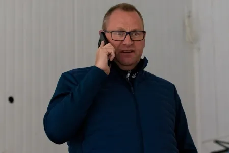 Toronto Maple Leafs GM Brad Treliving talks on the phone during an unidentified practice session.