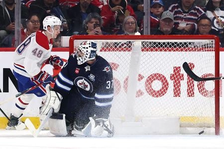 Feb 4, 2026; Winnipeg, Manitoba, CAN; Montreal Canadiens defenseman Lane Hutson (48) scores against Winnipeg Jets goaltender Connor Hellebuyck (37) in the second period at Canada Life Centre. Mandatory Credit: James Carey Lauder-Imagn Images