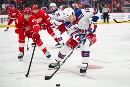 Apr 5, 2024; Detroit, Michigan, USA; New York Rangers left wing Artemi Panarin (10) brings the puck up ice against Detroit Red Wings defenseman Moritz Seider (53) during the first period at Little Caesars Arena.