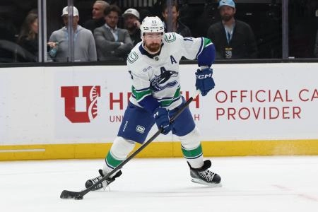 Feb 2, 2026; Salt Lake City, Utah, USA; Vancouver Canucks defenseman Filip Hronek (17) moves the puck against the Utah Mammoth during the second period at Delta Center.