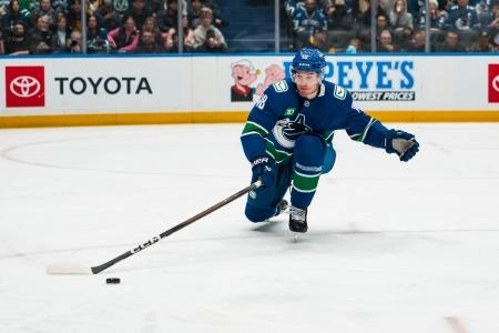Jan 25, 2026; Vancouver, British Columbia, CAN; Vancouver Canucks forward Drew O'Connor (18) reaches for the loose puck against the Pittsburgh Penguins in the first period at Rogers Arena.