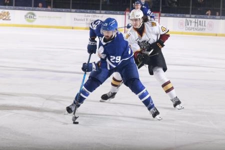 Toronto Marlies forward skates with the puck as a Chicago Wolves player gives chase during an AHL game.