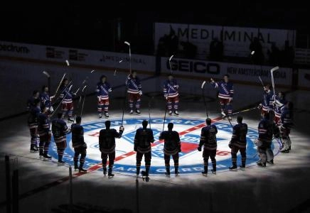 Jan 14, 2021; New York, NY, USA; New York Rangers players huddle around the center ice logo as they prepare for the home opener against the New York Islanders at Madison Square Garden.