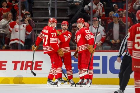 Nov 9, 2025; Detroit, Michigan, USA; Detroit Red Wings defenseman Simon Edvinsson (77) and defenseman Moritz Seider (53) celebrate a goal scored by center Dylan Larkin (71) during the first period at Little Caesars Arena.