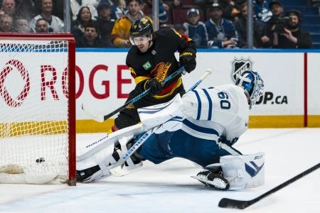 Jan 31, 2026; Vancouver, British Columbia, CAN; Toronto Maple Leafs goalie Joseph Woll (60) makes a save on Vancouver Canucks forward Conor Garland (8) in overtime at Rogers Arena.