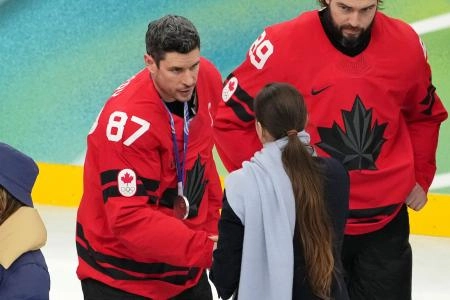 Feb 22, 2026; Milan, Italy; Sidney Crosby of Canada receives his silver medal in the men's ice hockey gold medal game during the Milano Cortina 2026 Olympic Winter Games at Milano Santagiulia Ice Hockey Arena. Mandatory Credit: James Lang-Imagn Images