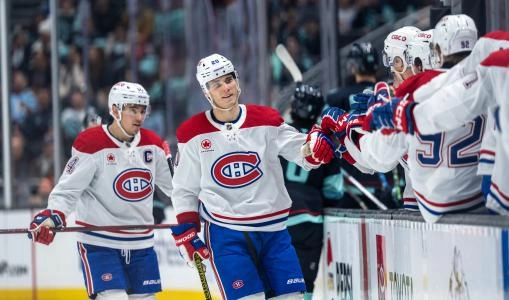 Mar 12, 2025; Seattle, Washington, USA; Montreal Canadiens forward Juraj Slafkovský (20) and forward Nick Suzuki (14), left, celebrate a goal against the Seattle Kraken with teammates on the bench during the third period at Climate Pledge Arena.