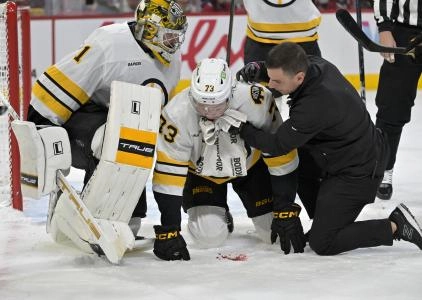 Nov 15, 2025; Montreal, Quebec, CAN; Boston Bruins defenseman Charlie McAvoy (73) is tended by a trainer and teammate goalie Jeremy Swayman (1) after receiving a shot in the mouth during the second period of the game against the Montreal Canadiens at the Bell Centre. Mandatory Credit: Eric Bolte-Imagn Images