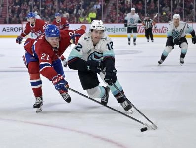 Oct 14, 2025; Montreal, Quebec, CAN; Seattle Kraken forward Tye Kartye (12) plays the puck and Montreal Canadiens defenseman Kaiden Guhle (21) defends during the third period at the Bell Centre.