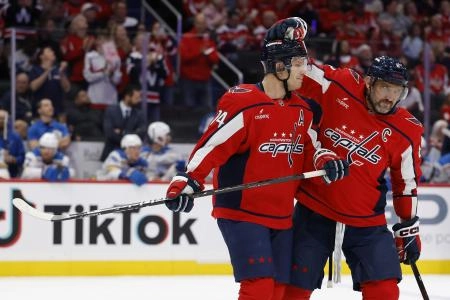 Nov 5, 2025; Washington, District of Columbia, USA; Washington Capitals defenseman John Carlson (74) is congratulated by Capitals left wing Alex Ovechkin (8) while being recognized for his 1,100th NHL point during a timeout against the St. Louis Blues during the first period at Capital One Arena.