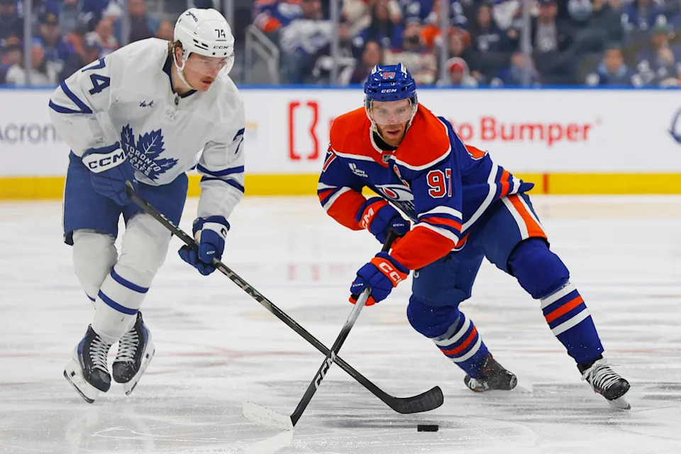 Toronto Maple Leafs forward Bobby McMann and Edmonton Oilers forward Connor McDavid battle for a loose puck.Perry Nelson-Imagn Images