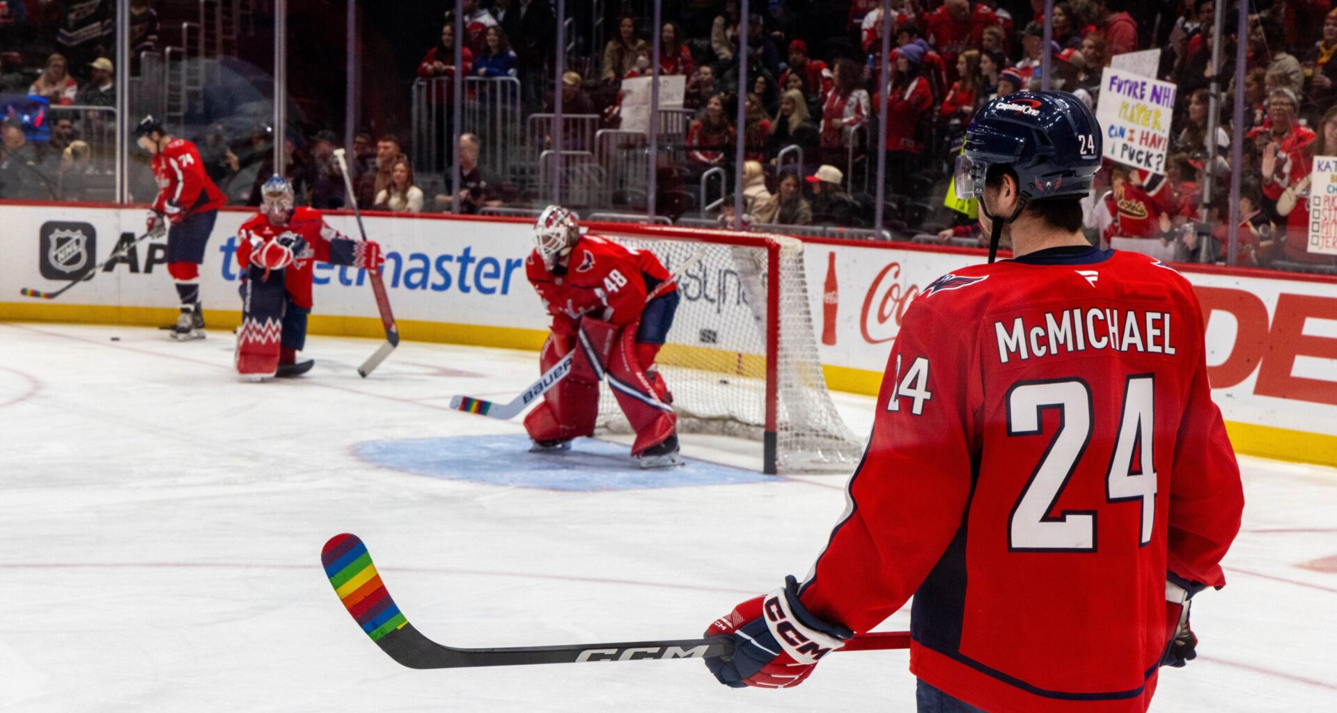 A Washington Capitals player holds a hockey stick wrapped in Pride Tape during Pride Night. Image courtesy of Evy Mages.