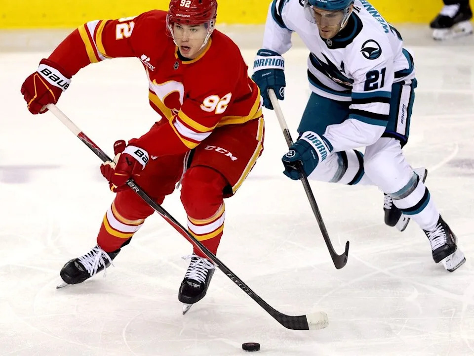  Flames forward Matvei Gridin is chased by Sharks forward Alexander Wennberg.