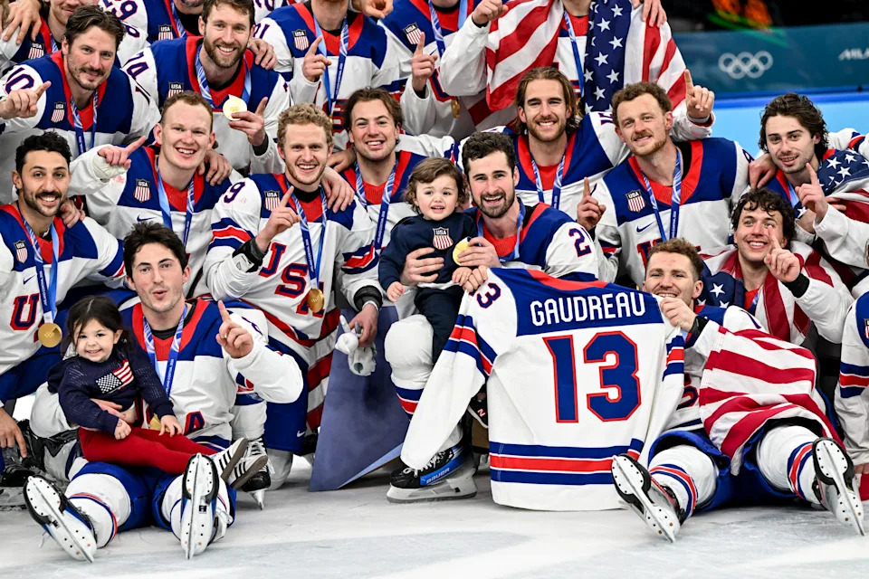 MILAN, ITALY - FEBRUARY 22: Team USA pose for a team photo with Johnny Gaudreau's children during the Ice Hockey Men's Gold Medal Game match between Canada and USA on day sixteen of the Milano Cortina 2026 Winter Olympic games at Milano Santagiulia Ice Hockey Arena on February 22, 2026 in Milan, Italy. (Photo by Andrea Branca/Eurasia Sport Images/Getty Images)