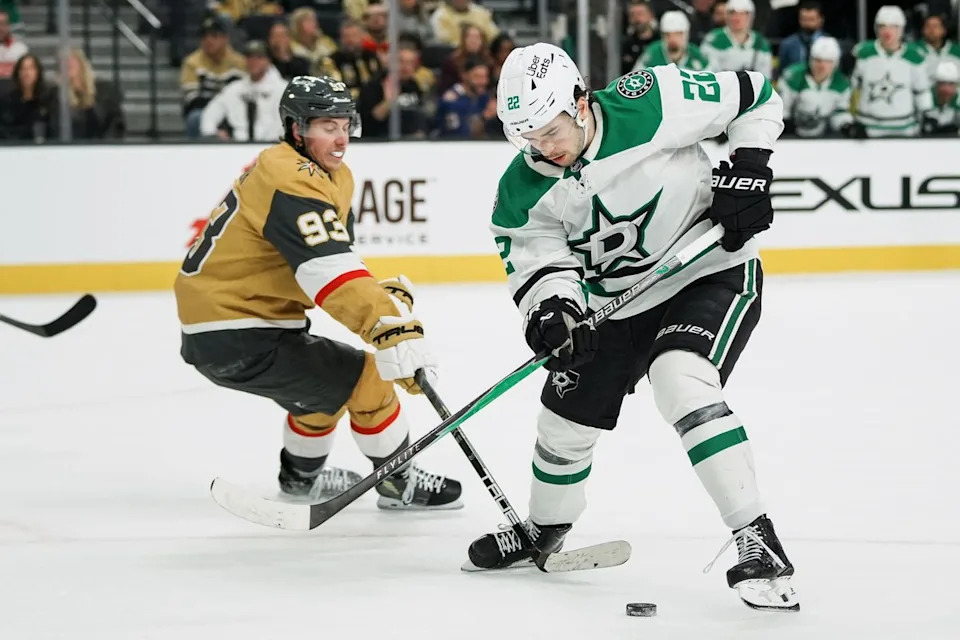 Dallas Stars center Mavrik Bourgque (22) scans down at the puck while Golden Knights right wing Mitch Marner (93) reaches for it  during overtime of NHL game against Vegas Golden Knights on Thursday Jan. 29, 2026 at T-Mobile Arena in Las Vegas.