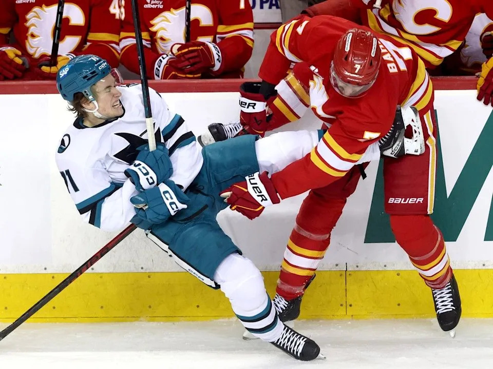  Flames defenceman Kevin Bahl battles Sharks forward Macklin Celebrini.