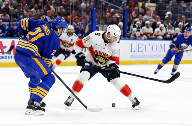Oct 18, 2025; Buffalo, New York, USA; Buffalo Sabres defenseman Conor Timmins (21) defends as Florida Panthers center Sam Bennett (9) looks to control the puck during the third period at KeyBank Center.