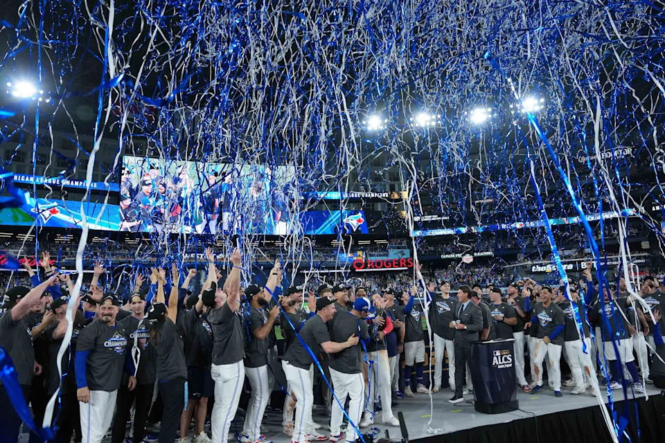 Oct 20, 2025; Toronto, Ontario, CAN; Streamers and confetti rain down on the stage of the Toronto Blue Jays players after defeating the Seattle Mariners in game seven of the ALCS round for the 2025 MLB playoffs at Rogers Centre. Mandatory Credit: Nick Turchiaro-Imagn Images