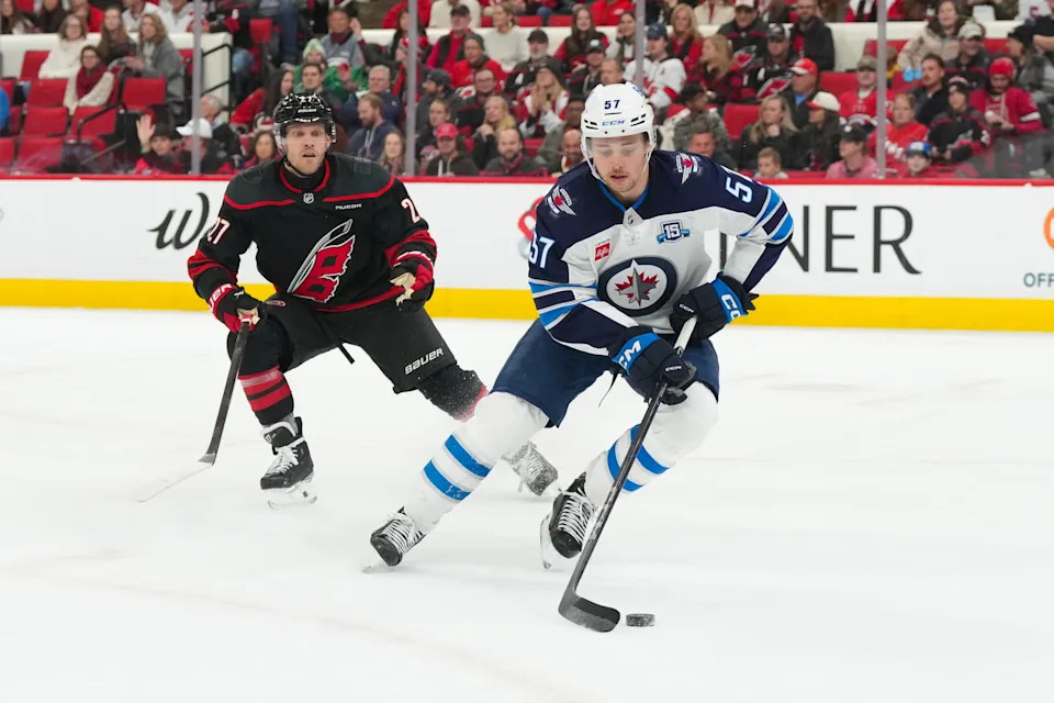 Manitoba Moose/Winnipeg Jets defenceman Elias Salomonsson (57) skates with the puck against Carolina Hurricanes forward Nikolaj Ehlers (27) during their game at Lenovo Center in Raleigh, NC. (Source: James Guillory-Imagn Images)