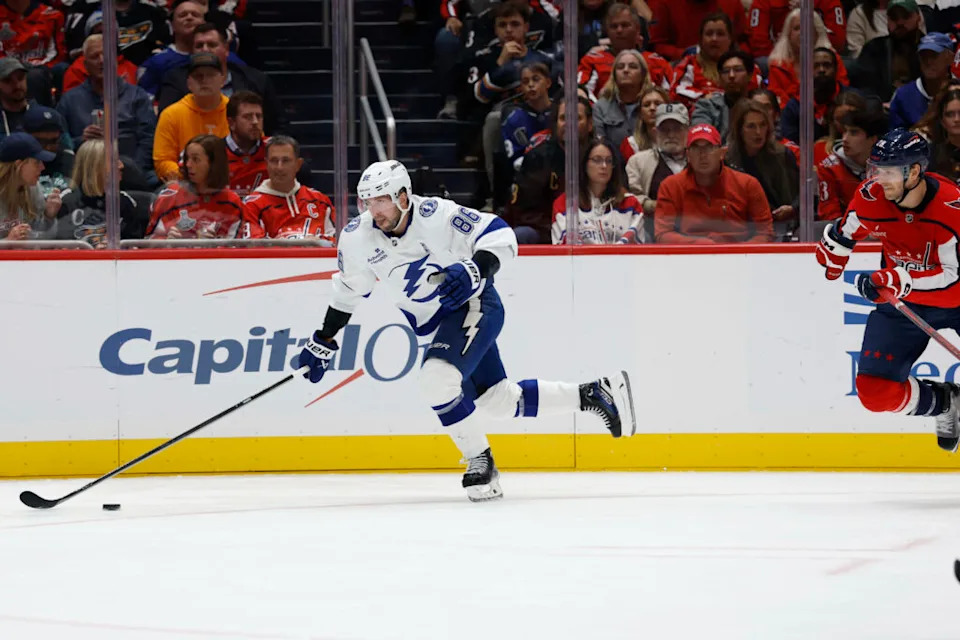 Oct 14, 2025; Washington, District of Columbia, USA; Tampa Bay Lightning right wing Nikita Kucherov (86) skates with the puck past Washington Capitals center Nic Dowd (26) in the second period at Capital One Arena. Mandatory Credit: Geoff Burke-Imagn Images