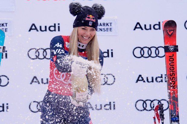 Lindsey Vonn sprays sparkling wine as she celebrates on the podium after winning a World Cup downhill in Zauchensee, Austria, Saturday, Jan. 10, 2026. (AP Photo/Giovanni Auletta)