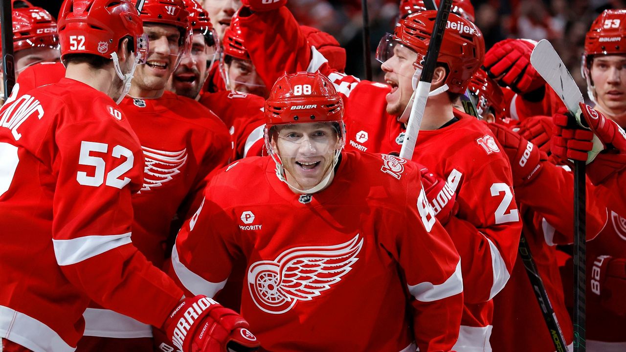 Detroit Red Wings right wing Patrick Kane (88) is surrounded by teammates after recording his 1,375th point to pass Mike Modano and break the NHL record for points by a player born in the United States, during the second period of an NHL hockey game Thursday, Jan. 29, 2026, in Detroit. (AP Photo/Duane Burleson)