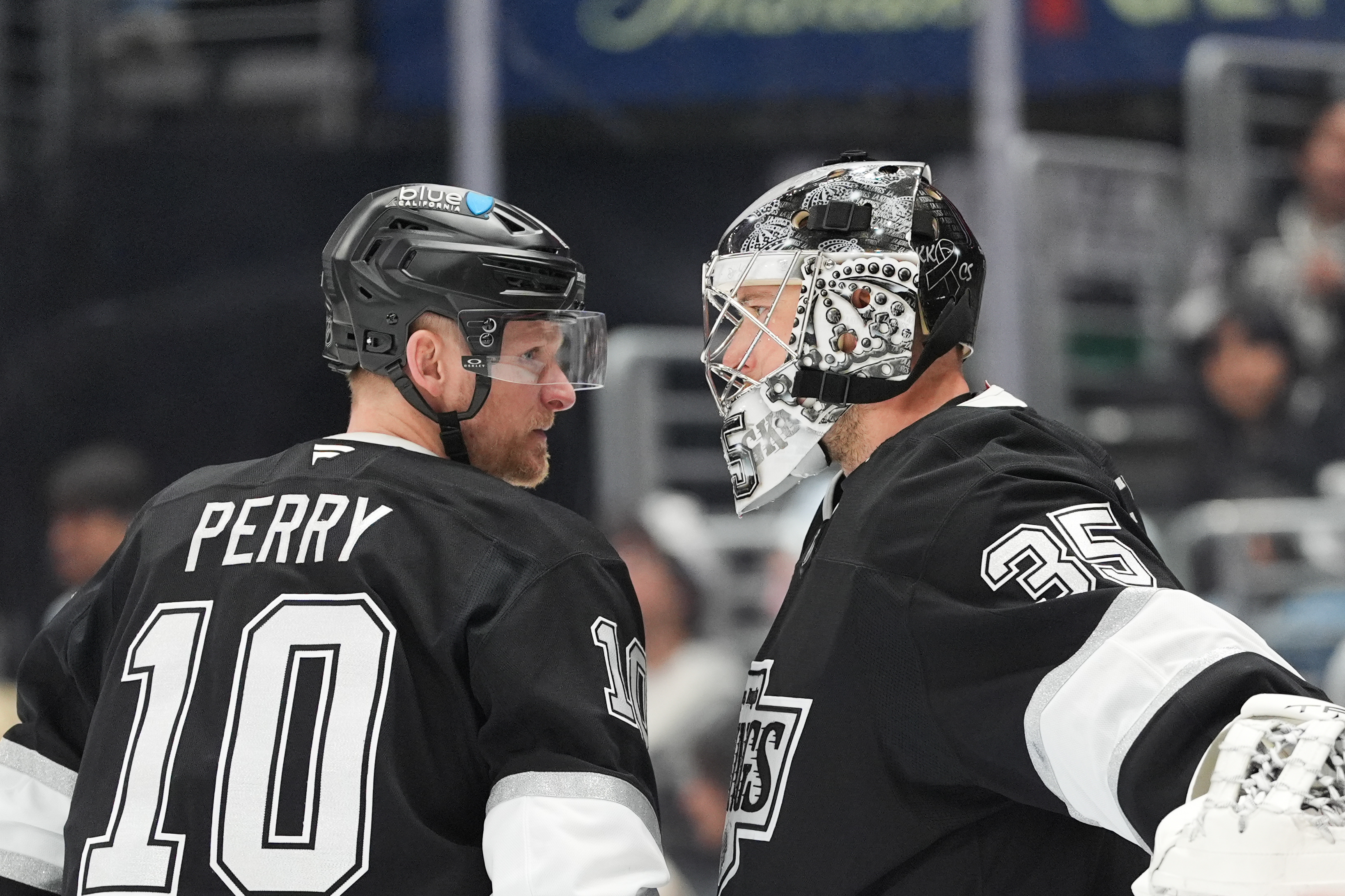 Kings right wing Corey Perry, left, talks with goaltender Darcy...