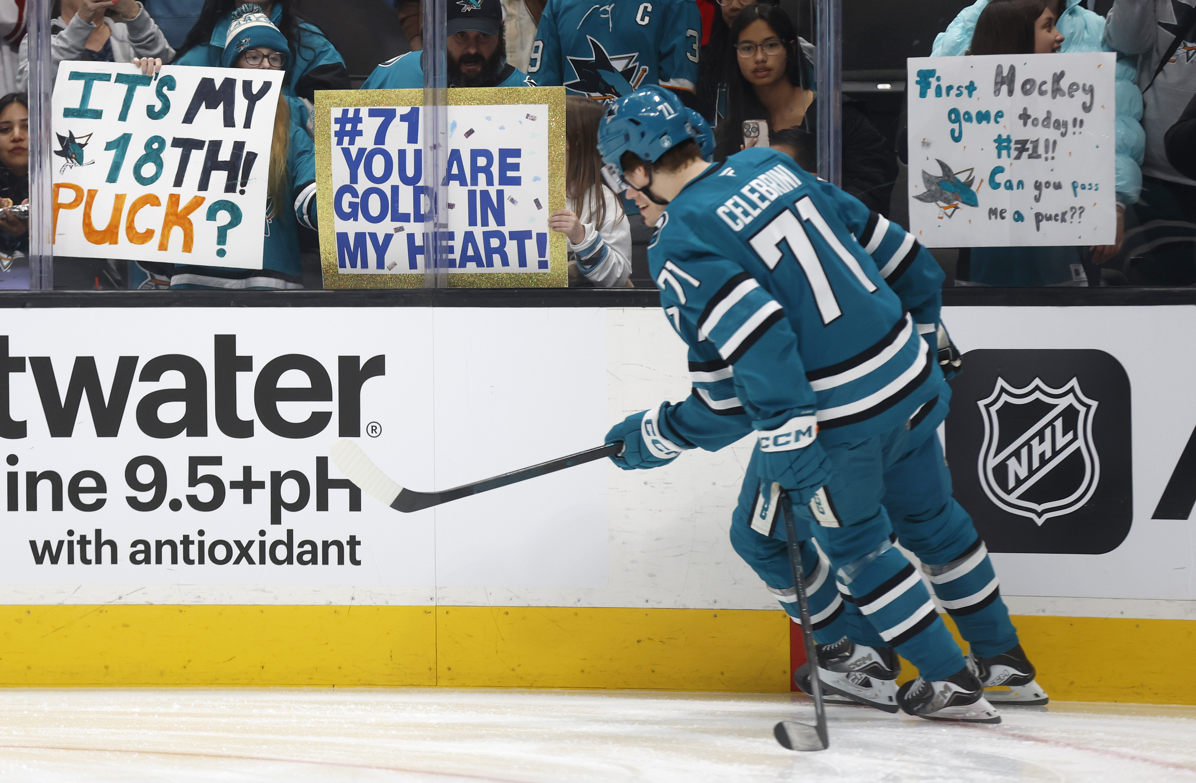 San Jose Sharks' Macklin Celebrini (71) skates past a sign...