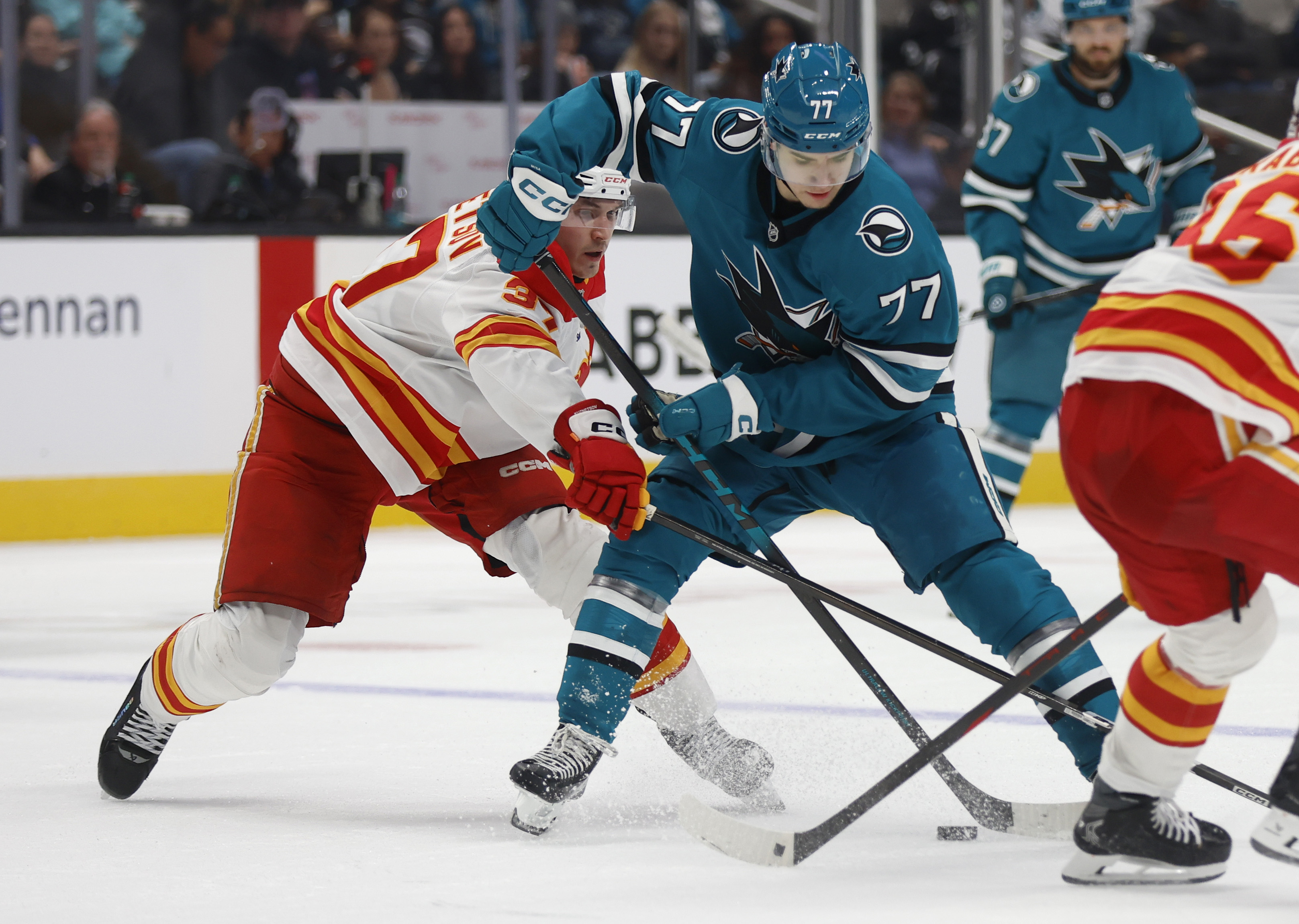 San Jose Sharks' Michael Misa (77) fights for the puck...