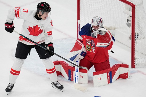 Canada's Macklin Celebrini scores his sides first goal past Czechia's goalkeeper Lukas Dostal during a preliminary round match of men's ice hockey between Czech Republic and Canada at the 2026 Winter Olympics, in Milan, Italy, Thursday, Feb. 12, 2026. (AP Photo/Petr David Josek)