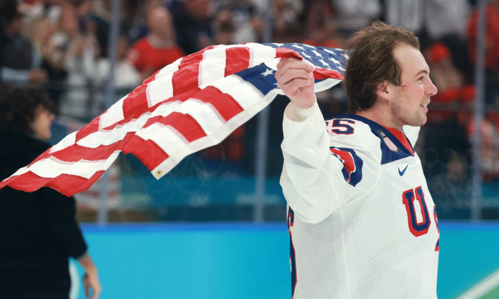 Charlie McAvoy (Bruins) skates with a USA flag after beating Canada 2-1 in the gold medal game